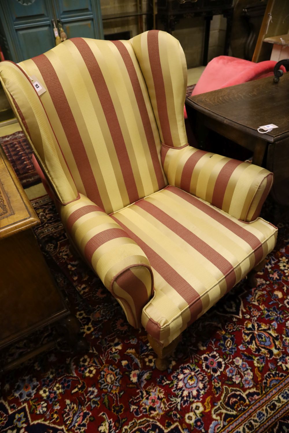 A 1920s wing armchair upholstered in striped fabric, width 80cm, depth 74cm, height 100cm